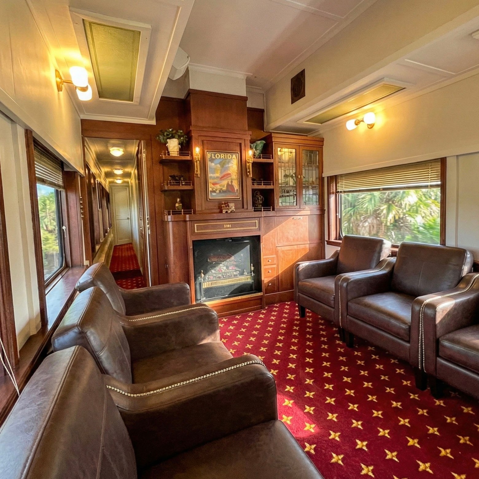 Vintage train car interior with leather chairs and a fireplace.