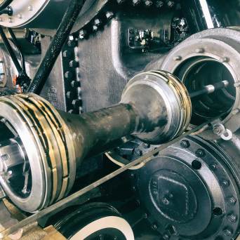 Close-up of a large industrial machine component with pistons and gears.