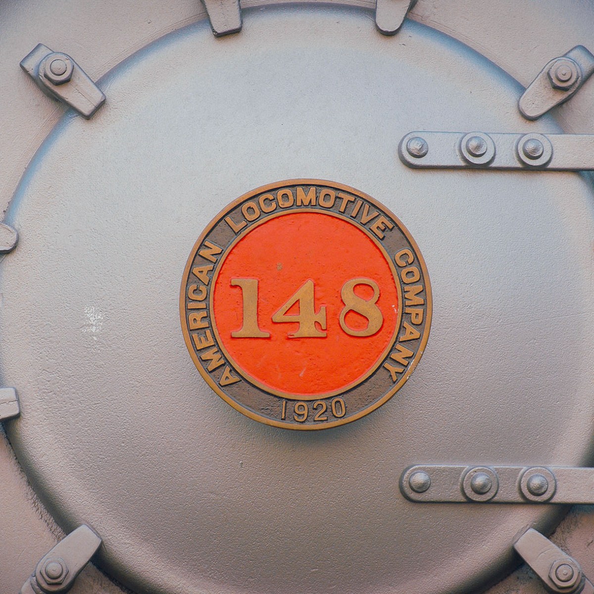 Close-up of a metal cover with 'American Locomotive Company 148 1920' on it.