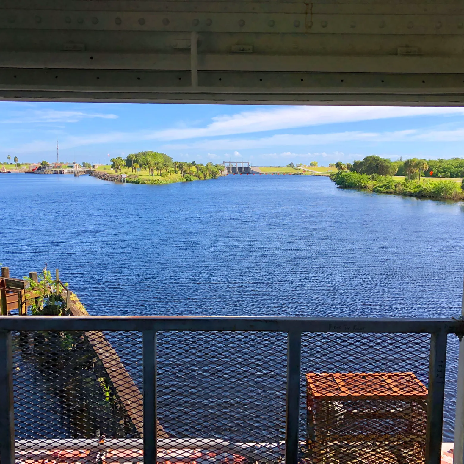 View of a river through a window with a metal railing.